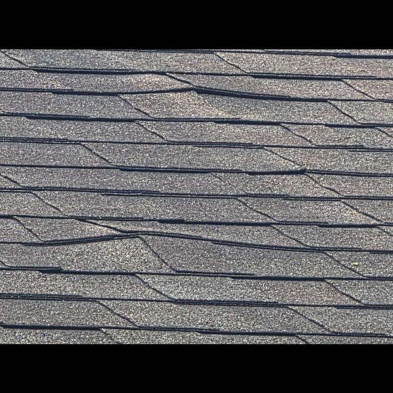Asphalt shingles with visible nail pops on roof surface Asphalt shingles with visible nail pops on roof surface