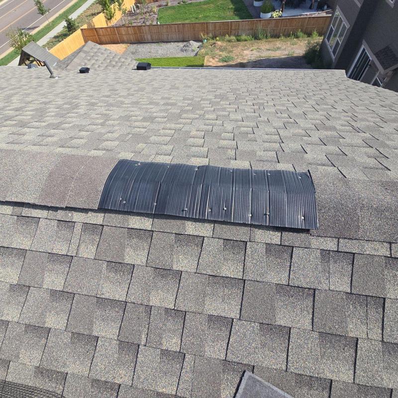 Roof ridge vent with newly secured shingles Roof ridge vent with newly secured shingles