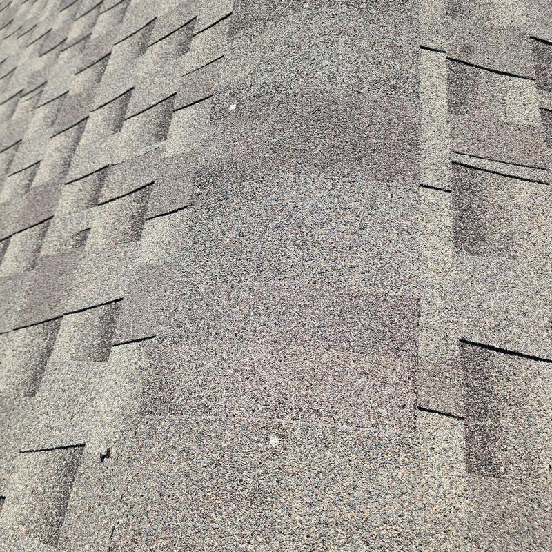 Asphalt shingles showing ridge section repair Asphalt shingles showing ridge section repair