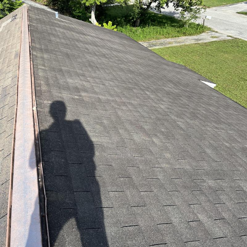Asphalt shingle roof with copper ridge cap installation