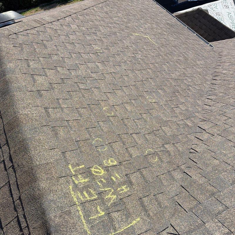 Asphalt shingle roof with marked hail damage spots