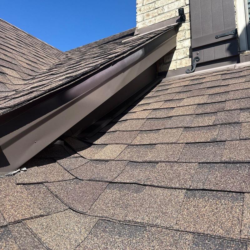 Roof shingles with hail damage near flashing installation