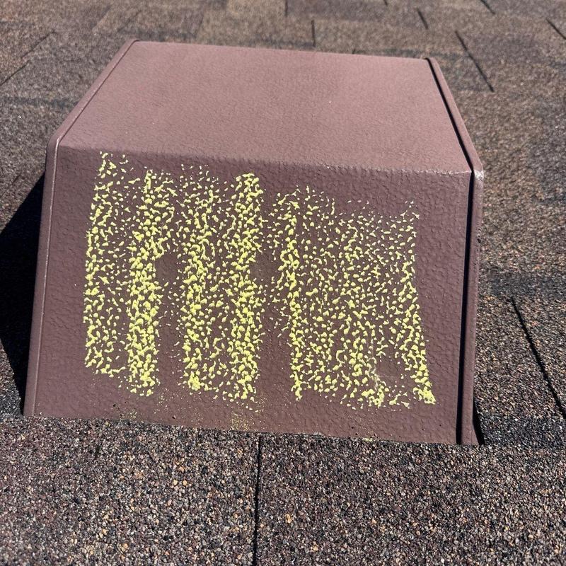 Roof vent with marked hail damage on shingles