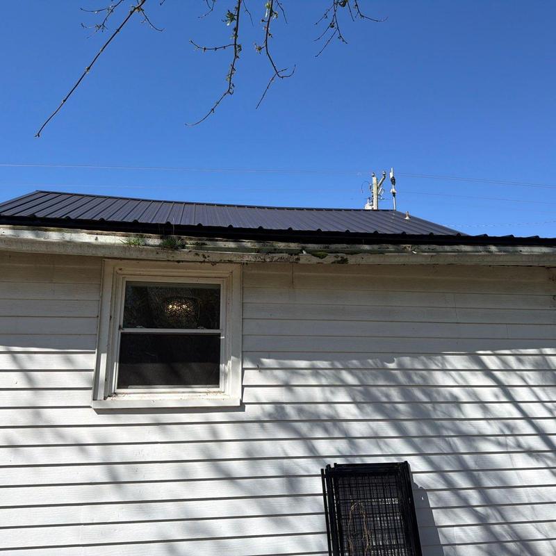 Metal roof panel installation on residential building exterior