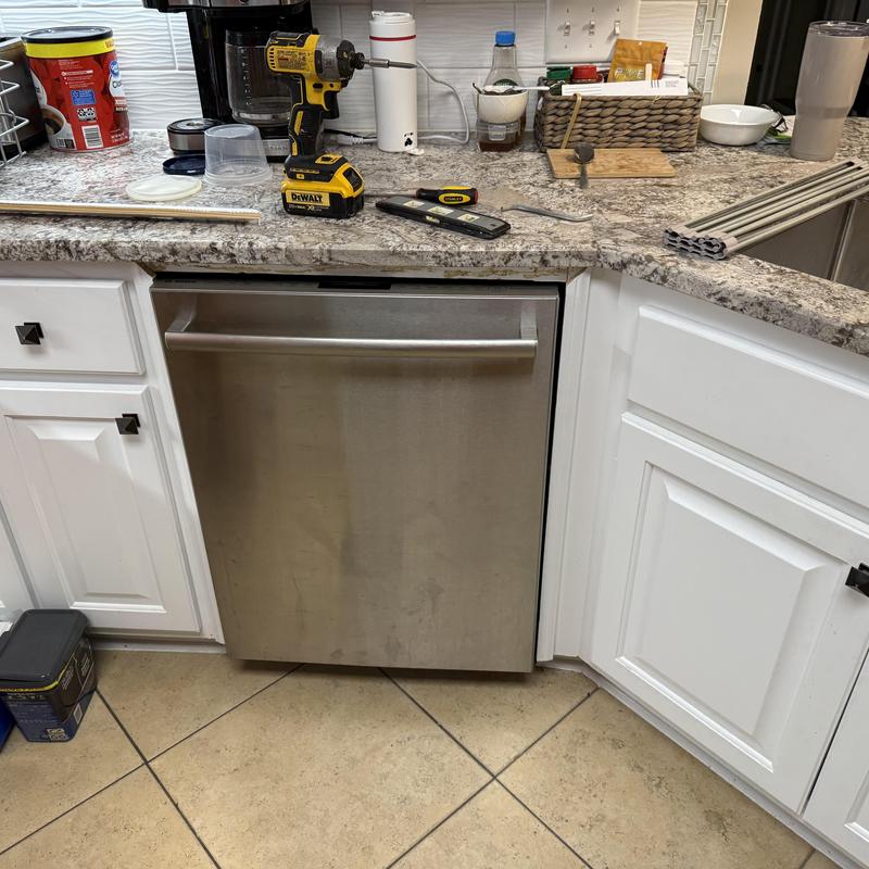 Dishwasher installation with adjustments and plumbing work