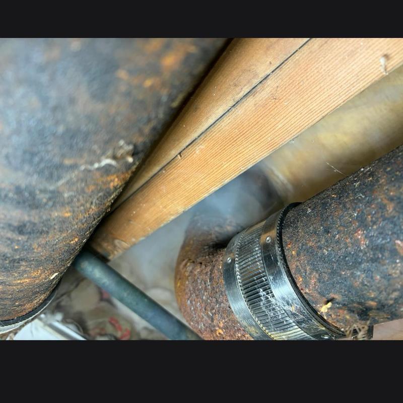 Toilet flange with metal clamp repair under floorboards