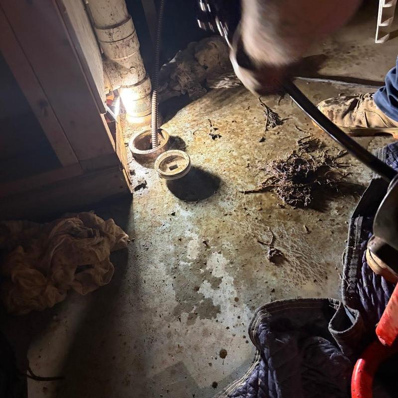 Main drain pipe snaking with clog removal in basement