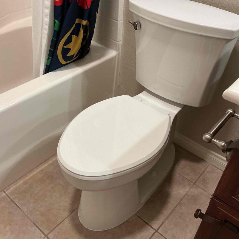 Toilet installation in bathroom with tiled floor