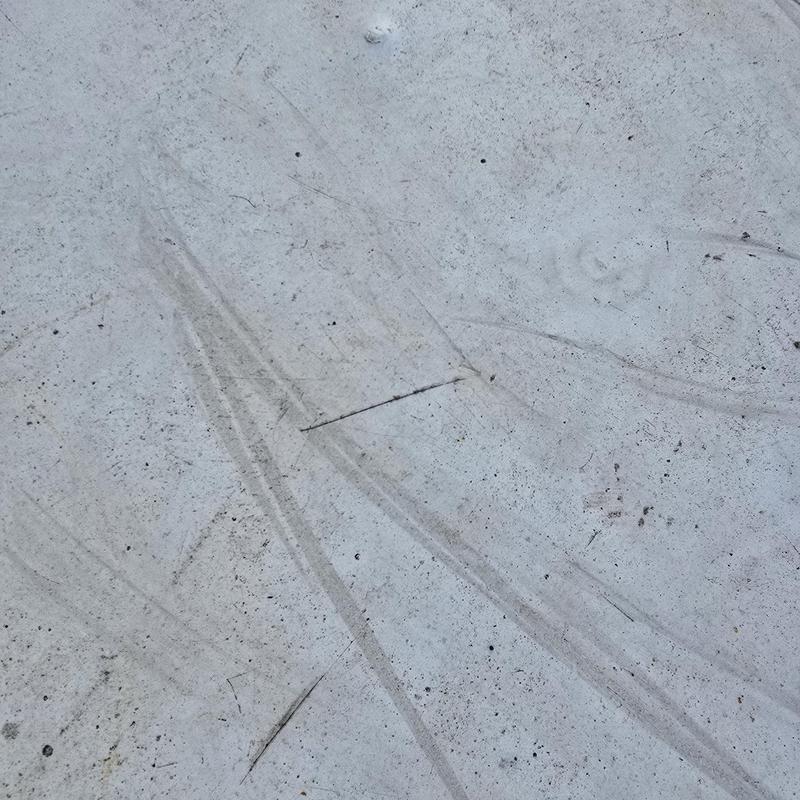 Flat roof surface with perforations and drag marks
