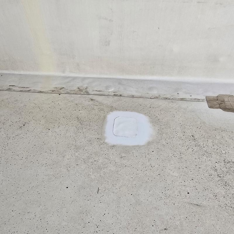 Flat roof patch with sealed pipe jack on concrete surface