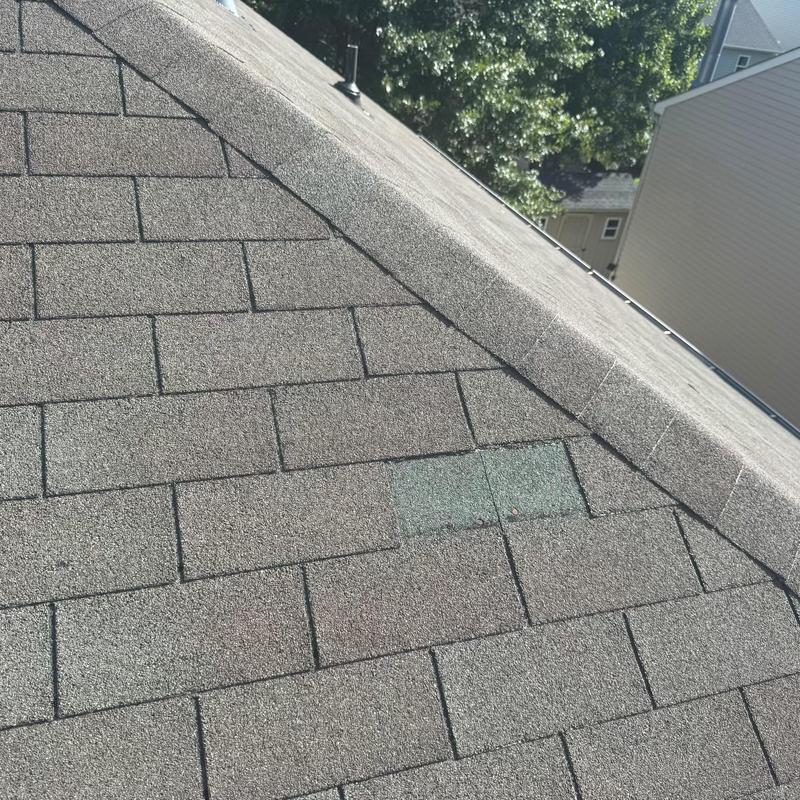 Three tab asphalt roof with replaced shingles near ridge Three tab asphalt roof with replaced shingles near ridge