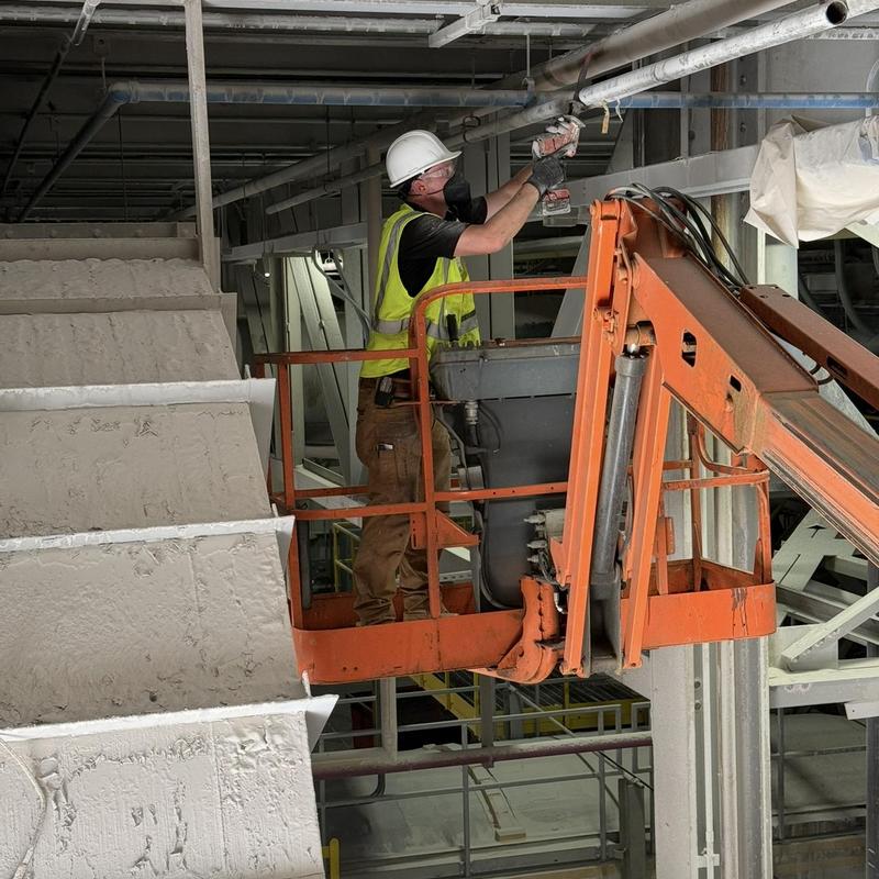 Gas line overhead pipe with worker on lift platform