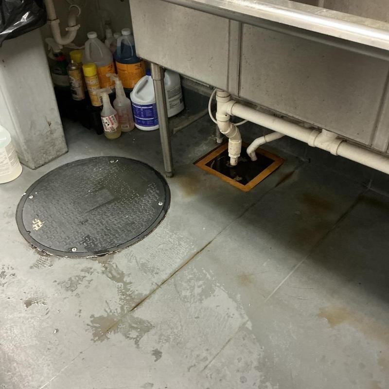 Floor drain under sink with cleared clog and pipes Floor drain under sink with cleared clog and pipes