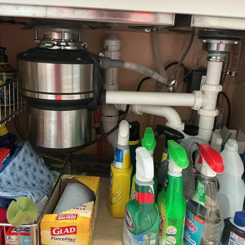 Garbage disposal with plumbing and cleaning supplies under sink Garbage disposal with plumbing and cleaning supplies under sink