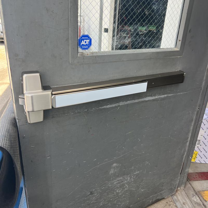 Exit device on gray metal door with window Exit device on gray metal door with window
