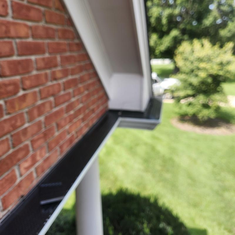 Gutter outlet with overflow prevention on brick home