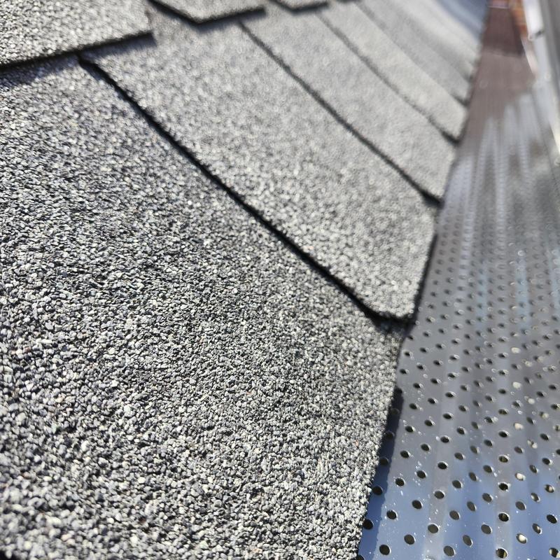 Gutter guard installation on shingle roof edge