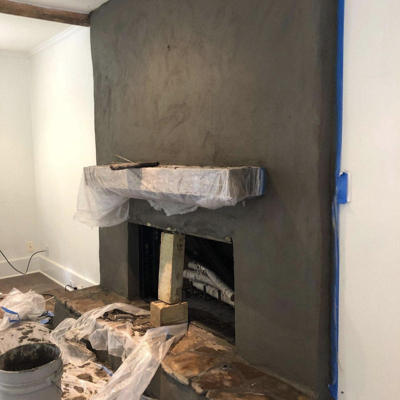 Stucco chimney surface with protected mantel during work
