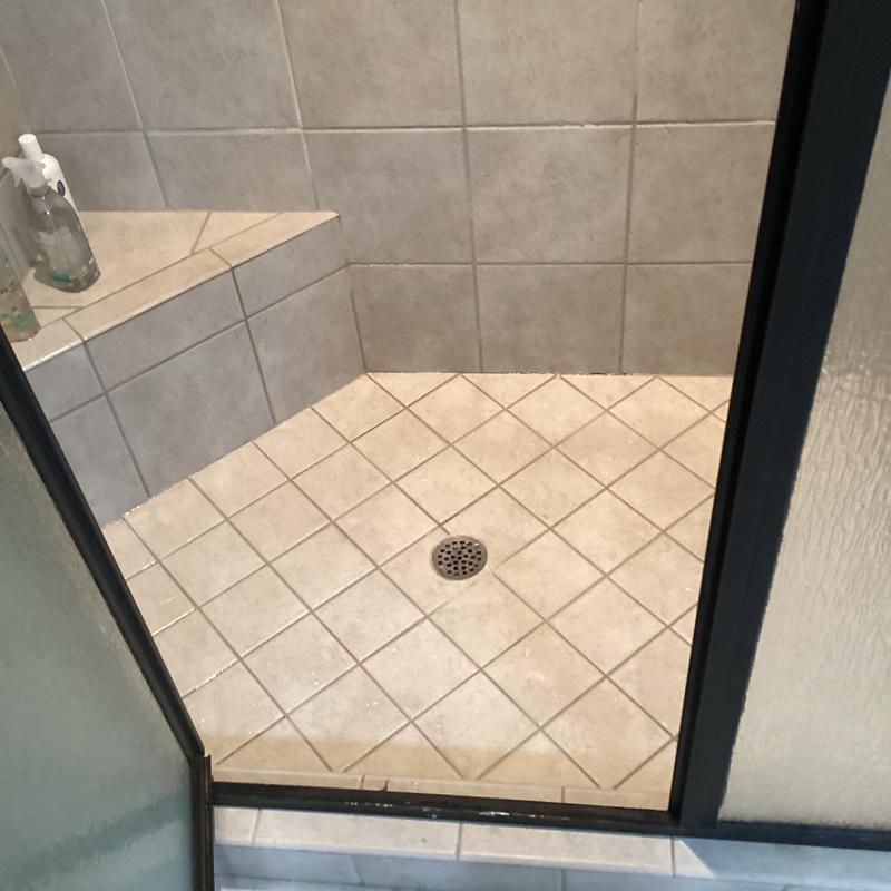 Shower drain with tiled floor and bench inside shower