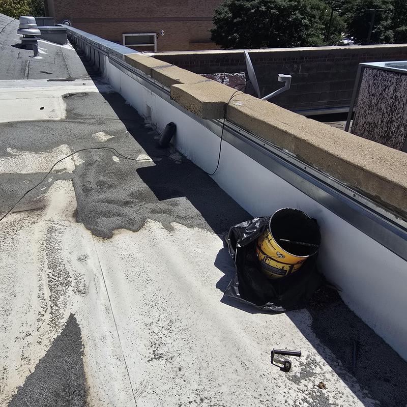 Modified bitumen flat roof with cleared scupper drains