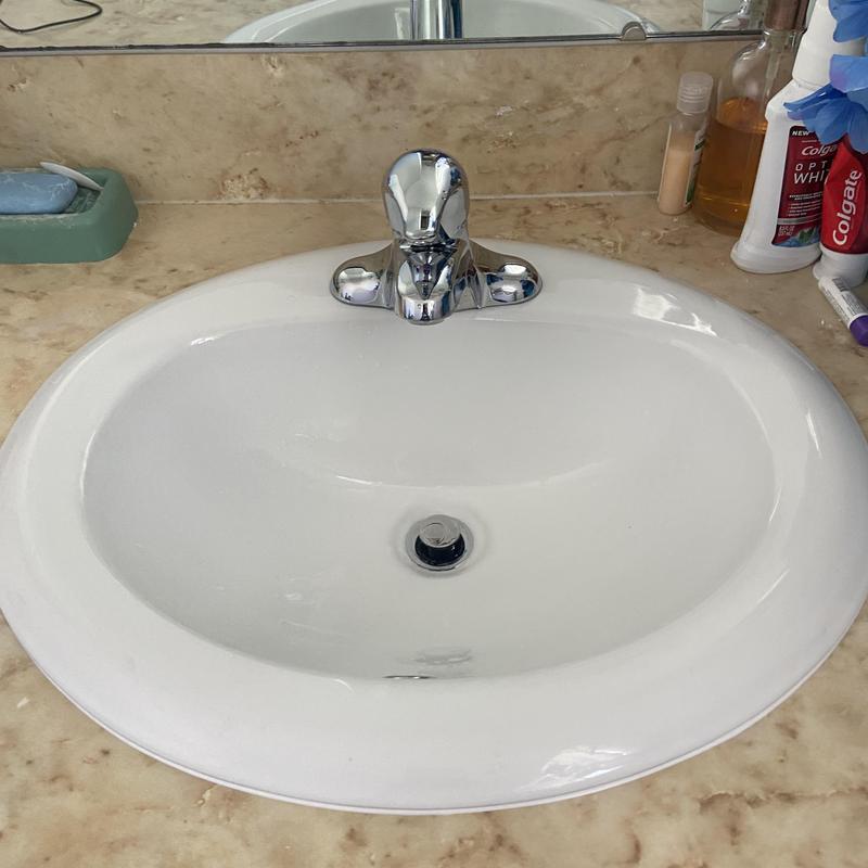 Bathroom sink with chrome faucet on marble countertop