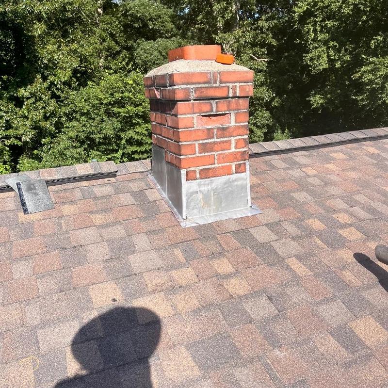 Brick chimney flashing on asphalt shingle roof in Mystic CT