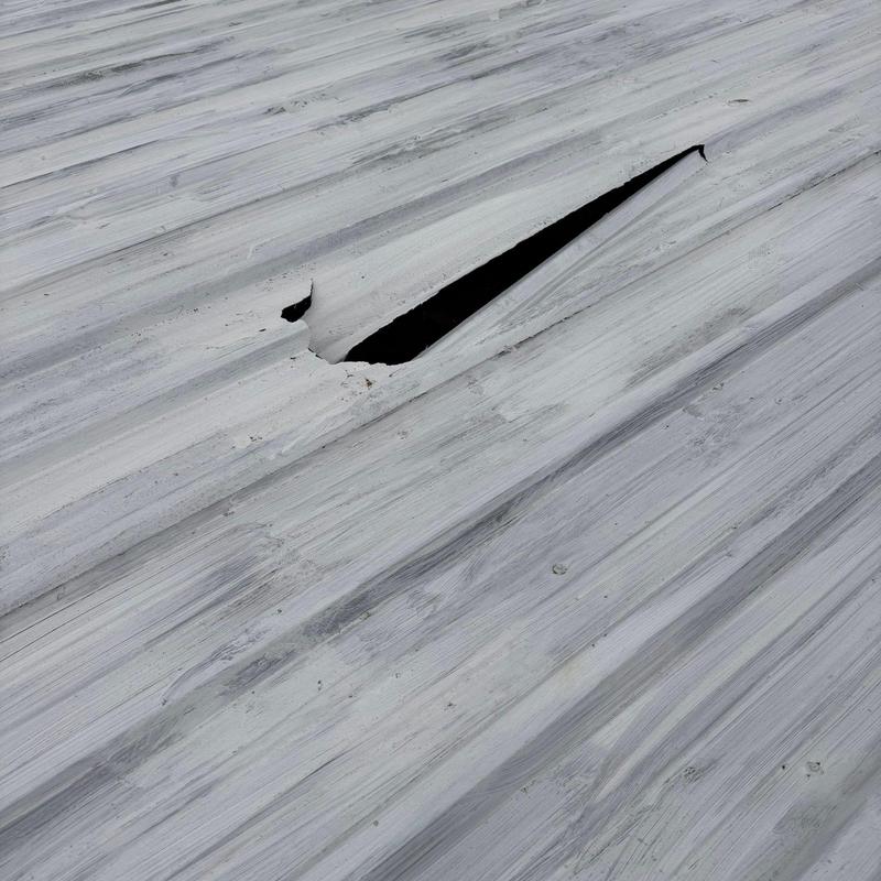 Metal roofing panel with large tear and damage
