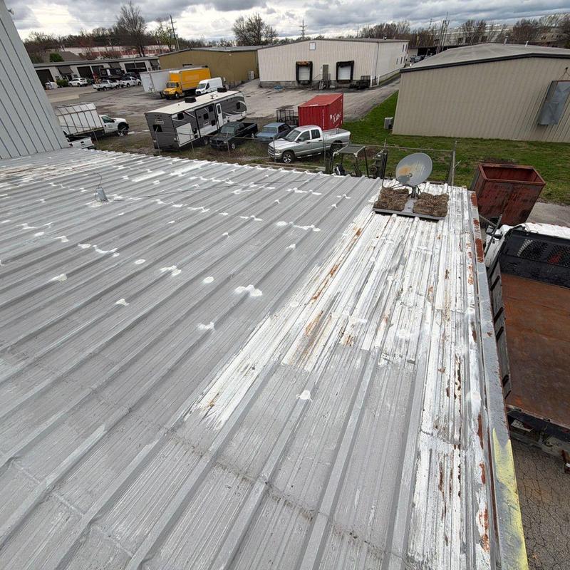 Metal commercial roof with hail damage and rust spots