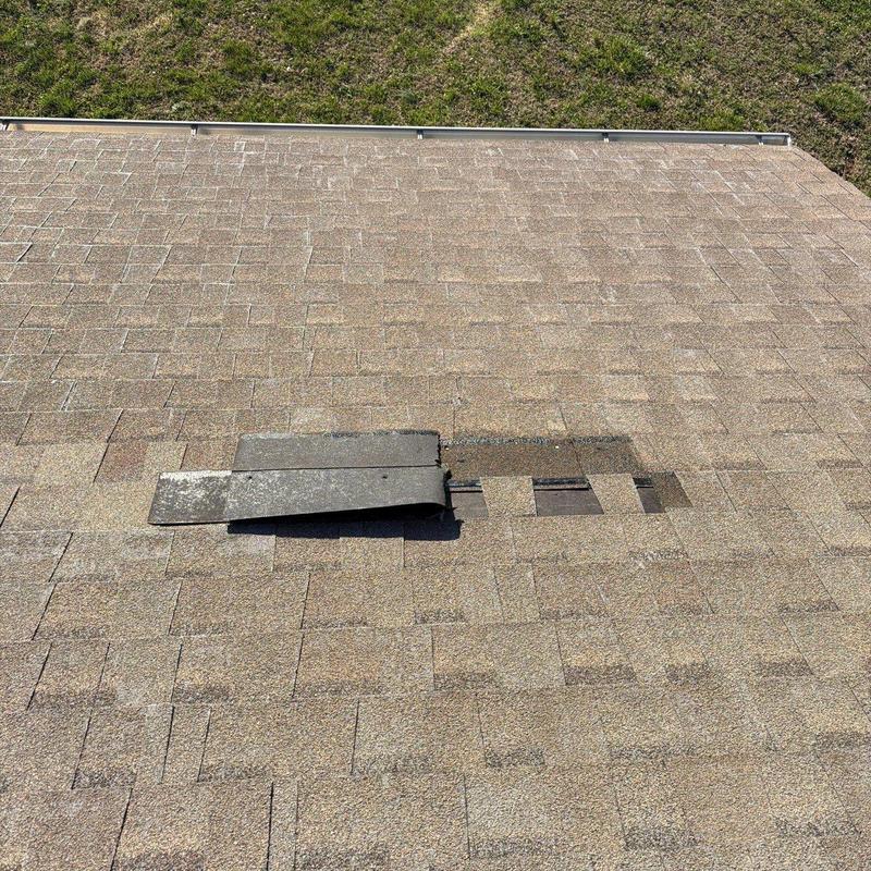 Asphalt shingles with hail damage and lifted tab