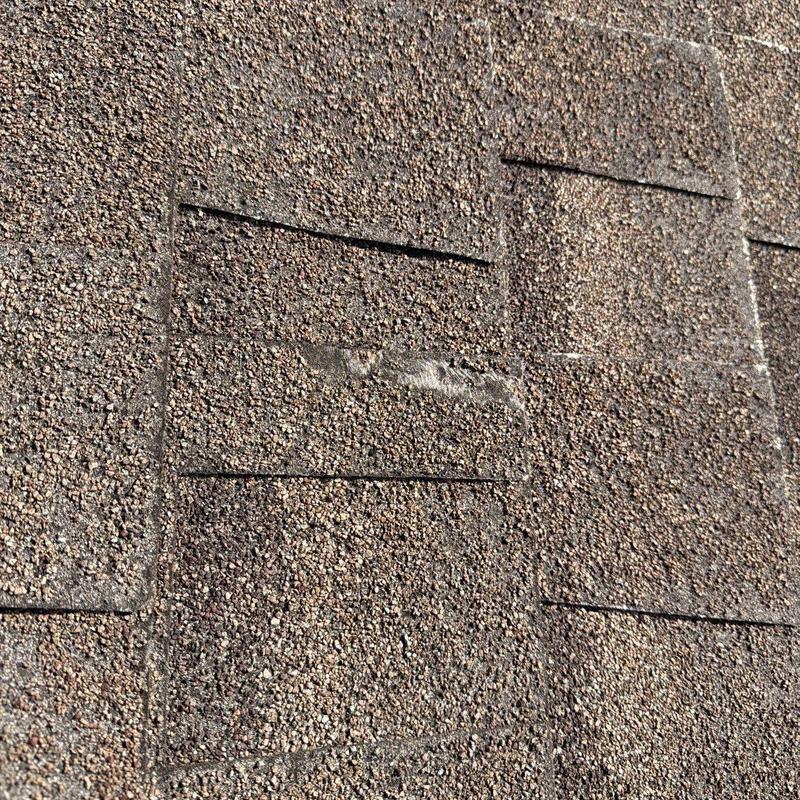 Asphalt roof shingles with hail damage close-up