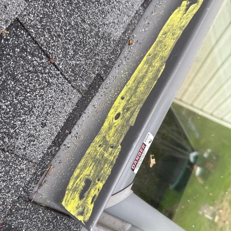 Metal flashing with hail damage marked in yellow paint
