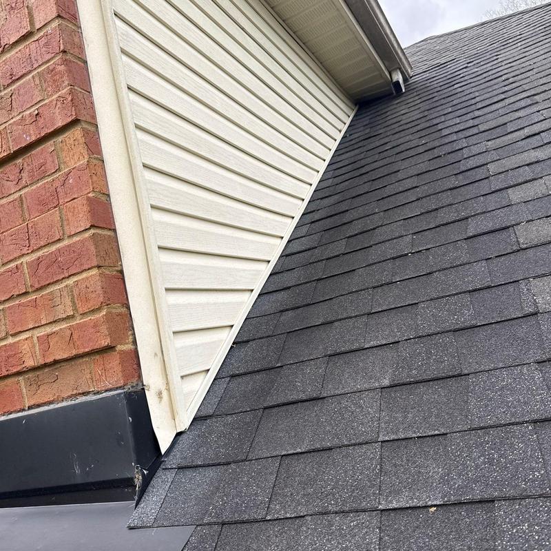 Roof shingles and flashing near brick chimney