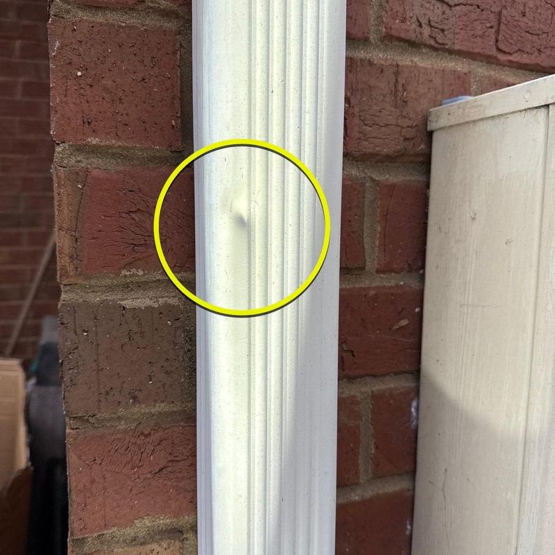 Vinyl downspout dent on brick wall exterior