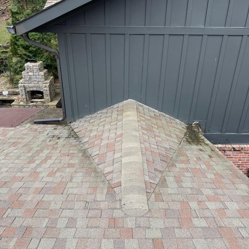 Roof shingles with hail damage near wall flashing