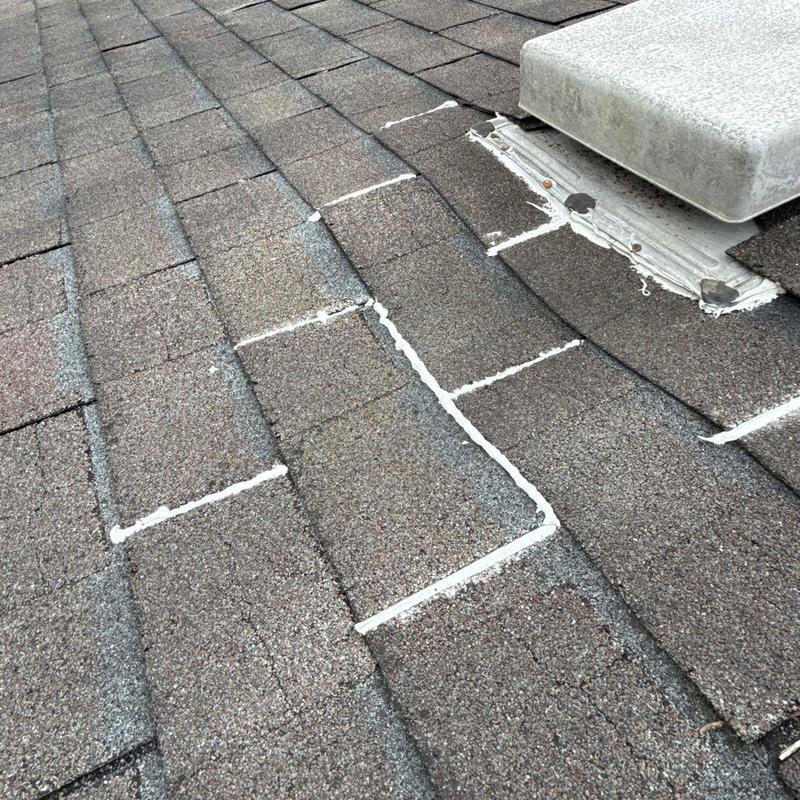Asphalt roof shingles with hail damage marked for repair