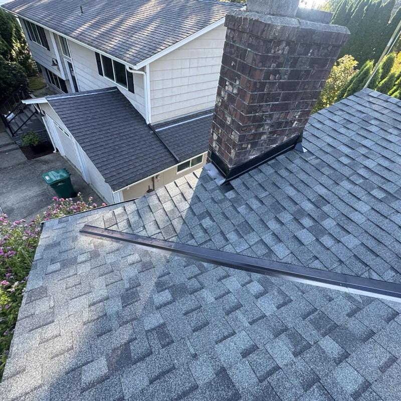 Asphalt shingle roof with brick chimney flashing