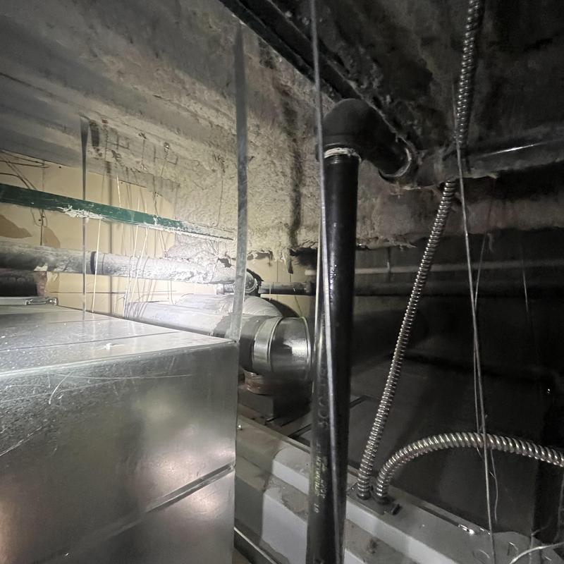Cast iron waste line in basement ceiling with ductwork Cast iron waste line in basement ceiling with ductwork