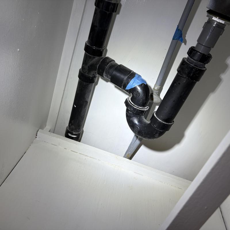 Black PVC sink drain pipe under cabinet with tape Black PVC sink drain pipe under cabinet with tape