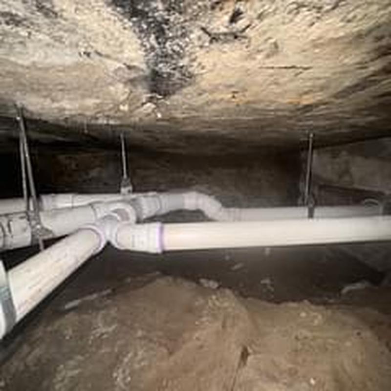 PVC drain pipes installed under crawlspace with hangers