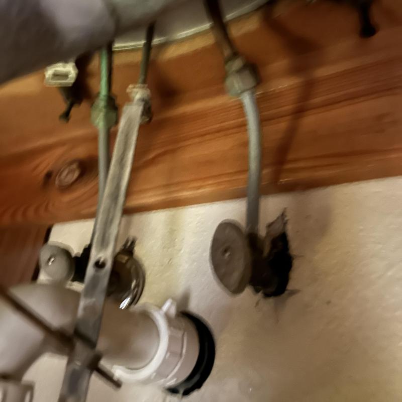 Supply lines under sink with shutoff valves and drain pipe Supply lines under sink with shutoff valves and drain pipe