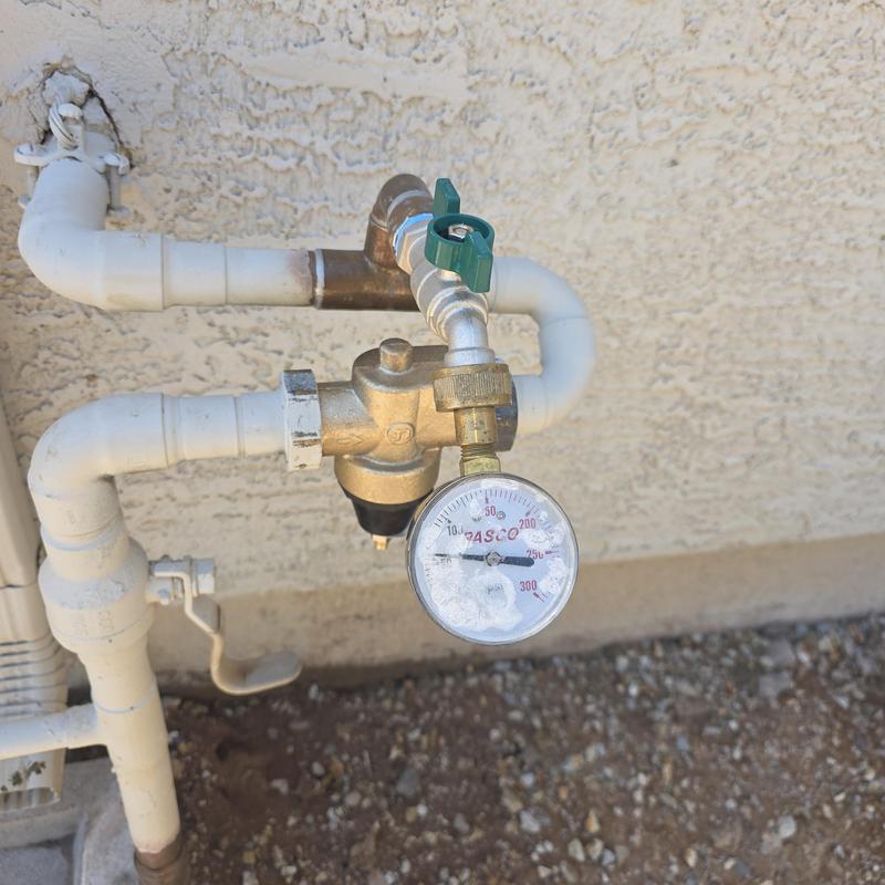 Pressure reducing valve with attached hose bib and gauge