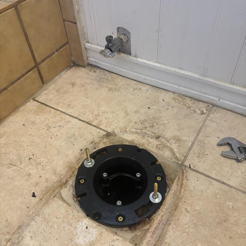 Toilet flange installation on tiled bathroom floor