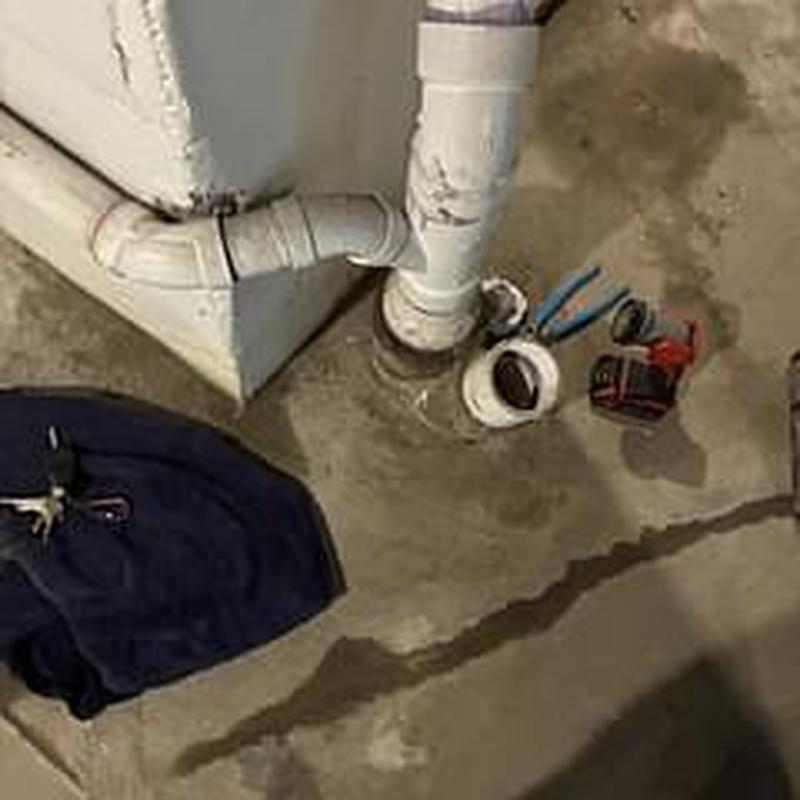 PVC drain pipe with plumbing tools on concrete floor
