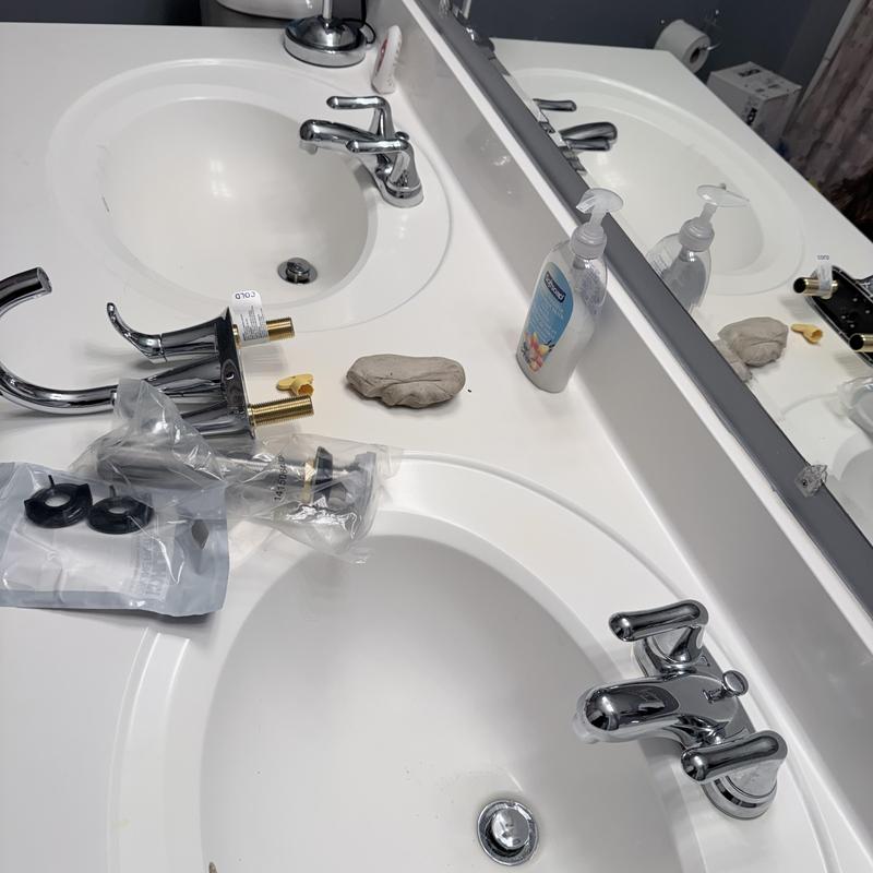 Double vanity faucets with parts on countertop Double vanity faucets with parts on countertop