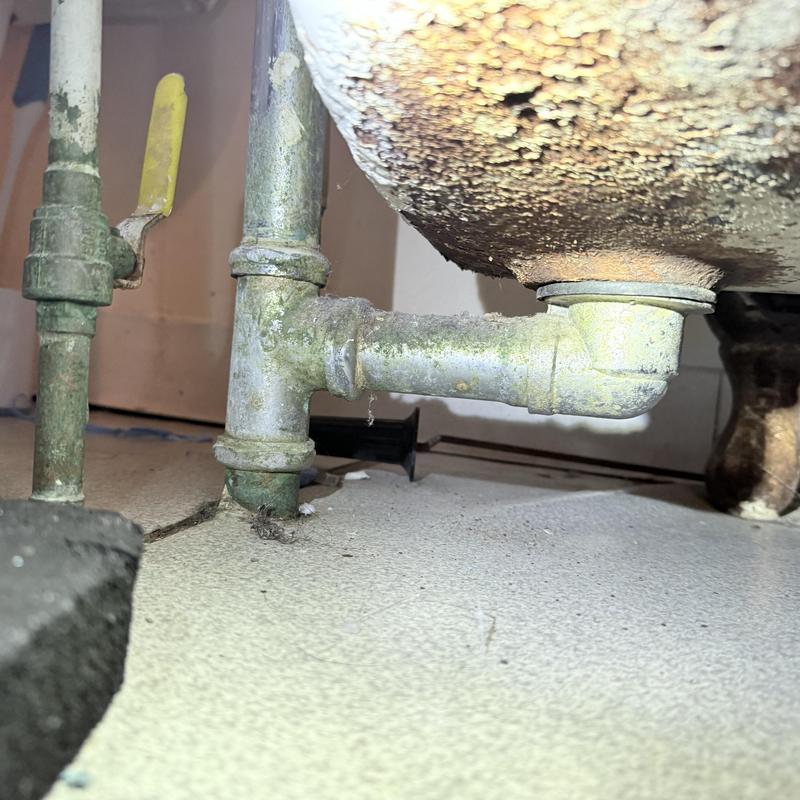 Bathtub drain pipe with corrosion and leak signs Bathtub drain pipe with corrosion and leak signs