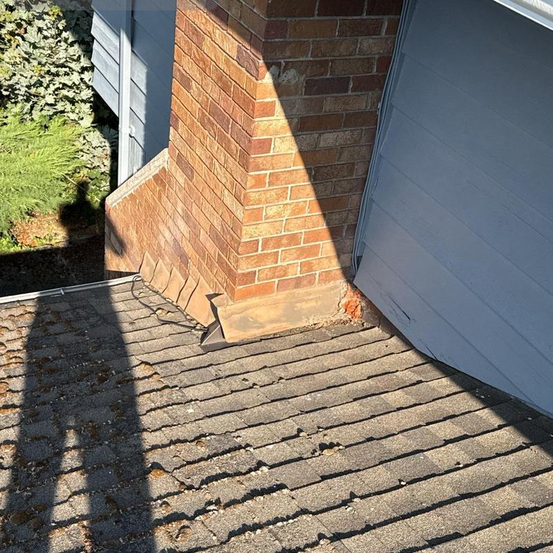 Chimney flashing and shingle roof inspection on house