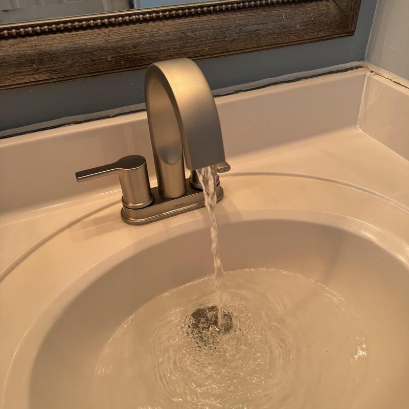 Lavatory faucet flowing water in bathroom sink