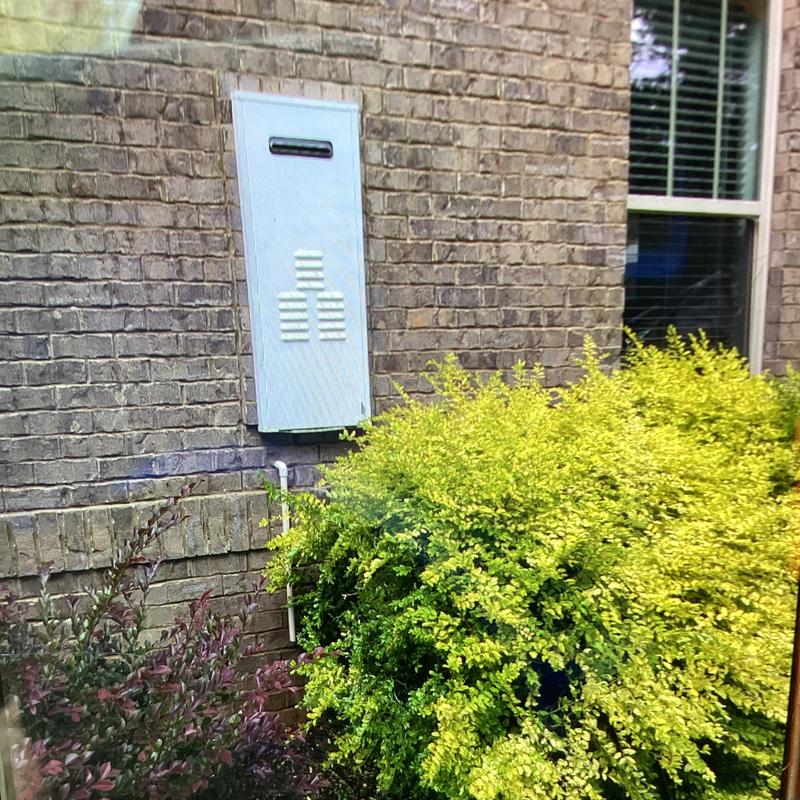 Tankless water heater outdoor unit on brick wall