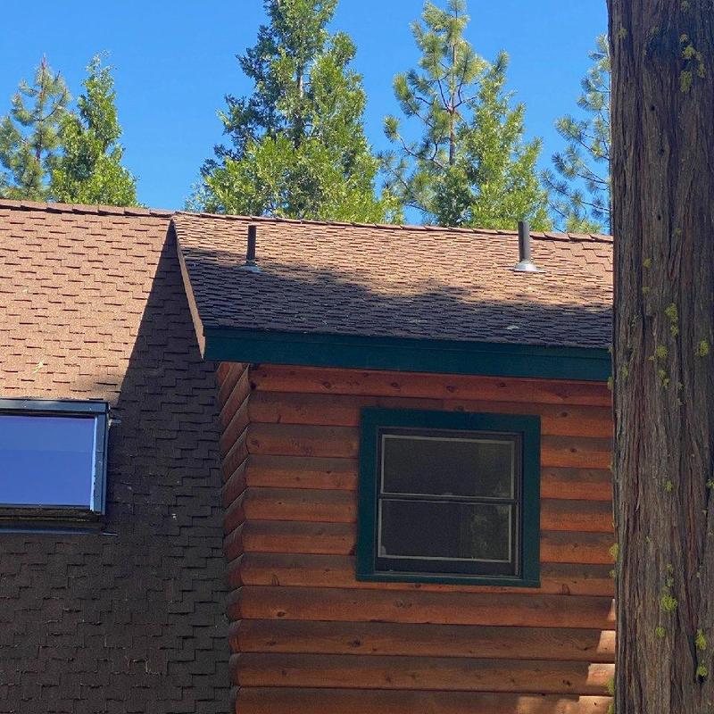 Snow splitter and chimney brace on cabin roof