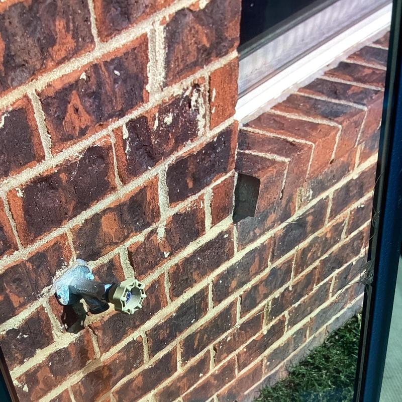 Hose bib with replaced flat washers on brick wall